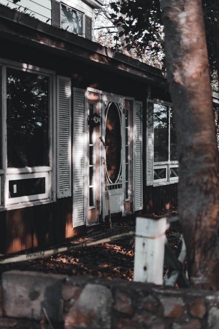 An abandoned house with a decaying facade, featuring wooden elements and a rustic charm.