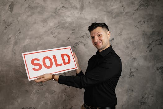 pexels-photo-7642009-7642009 Happy realtor holding a 'Sold' sign, symbolizing successful property sale.